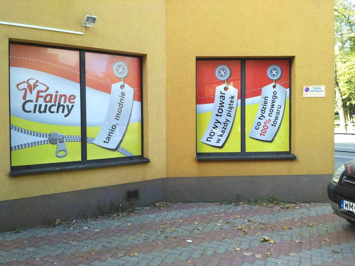 szyby oklejone reklamą z folii dziurkowanej okna sklepu