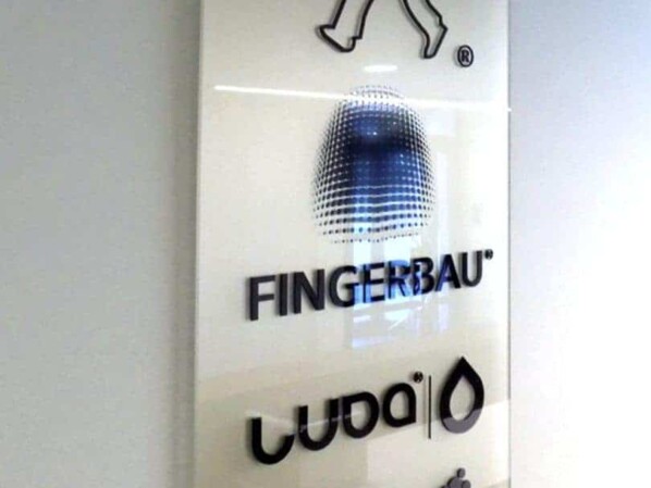 tablica pleksi na ścianie naklejone znaki firmowe logo