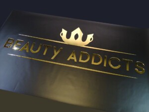 Złote logo lustrzany pleksiglas reklama salonu kosmetycznego