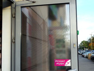 Reklama perforowana dziurkowana folia na szybie drzwi jak wygląda od środka pomieszczenia